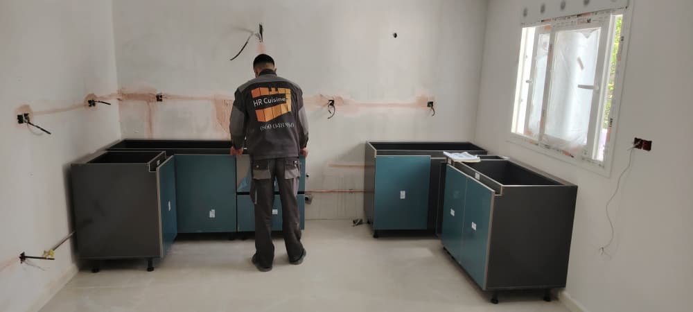 Technicien HR Cuisine installant des caissons de cuisine sur chantier