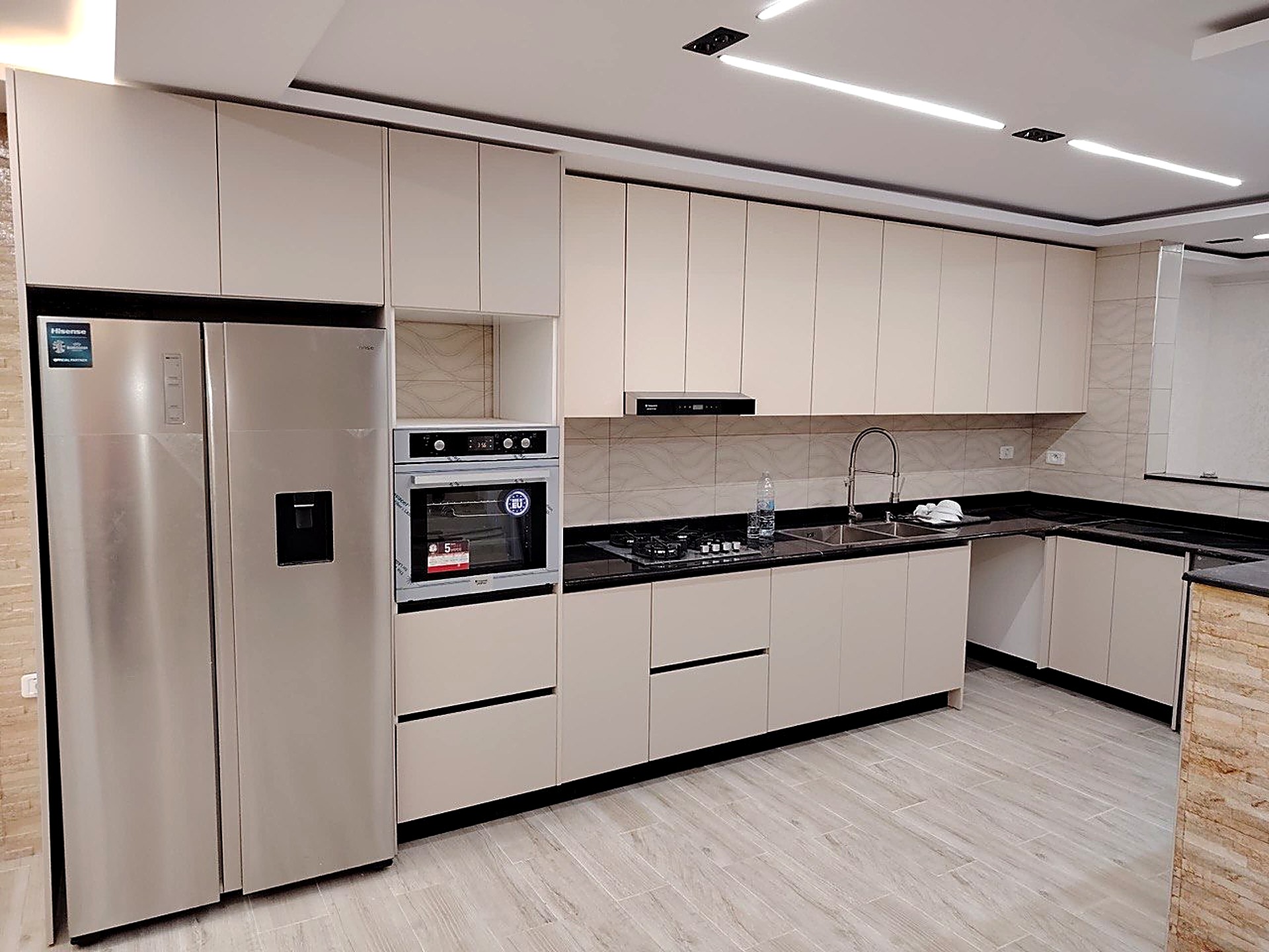 Cuisine HR Cuisine beige, plan de travail noir et credence marbre