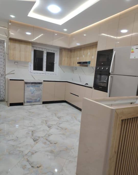 Cuisine HR Cuisine beige laquee, mur en pierre et caisson cannele