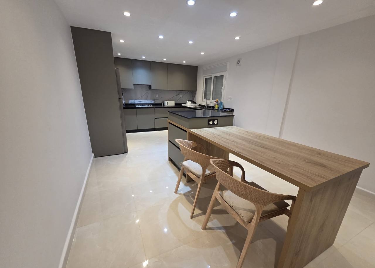 Cuisine HR Cuisine grise, ilot central et coin repas bois clair